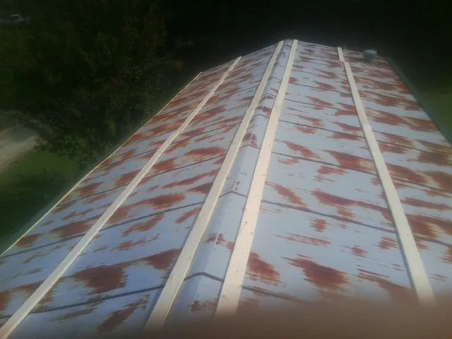 Rusted metal roof panels with new wood purlins before replacement — Storm Damage Roof Repair in Boerne by Roofing Brothers