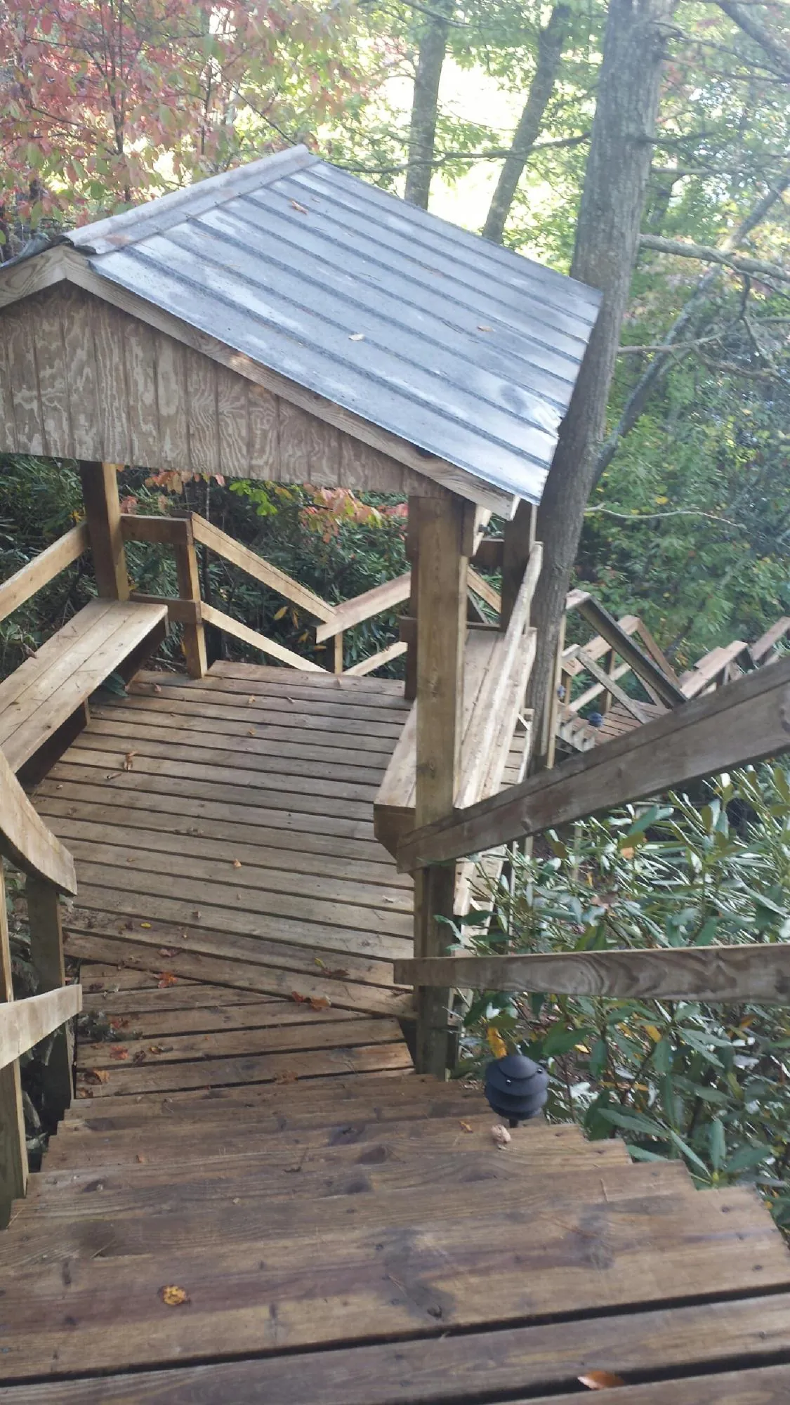 Metal roofed shelter over wooden steps on a wooded walkway — Skylight Repair & Installation work by our crew in Boerne