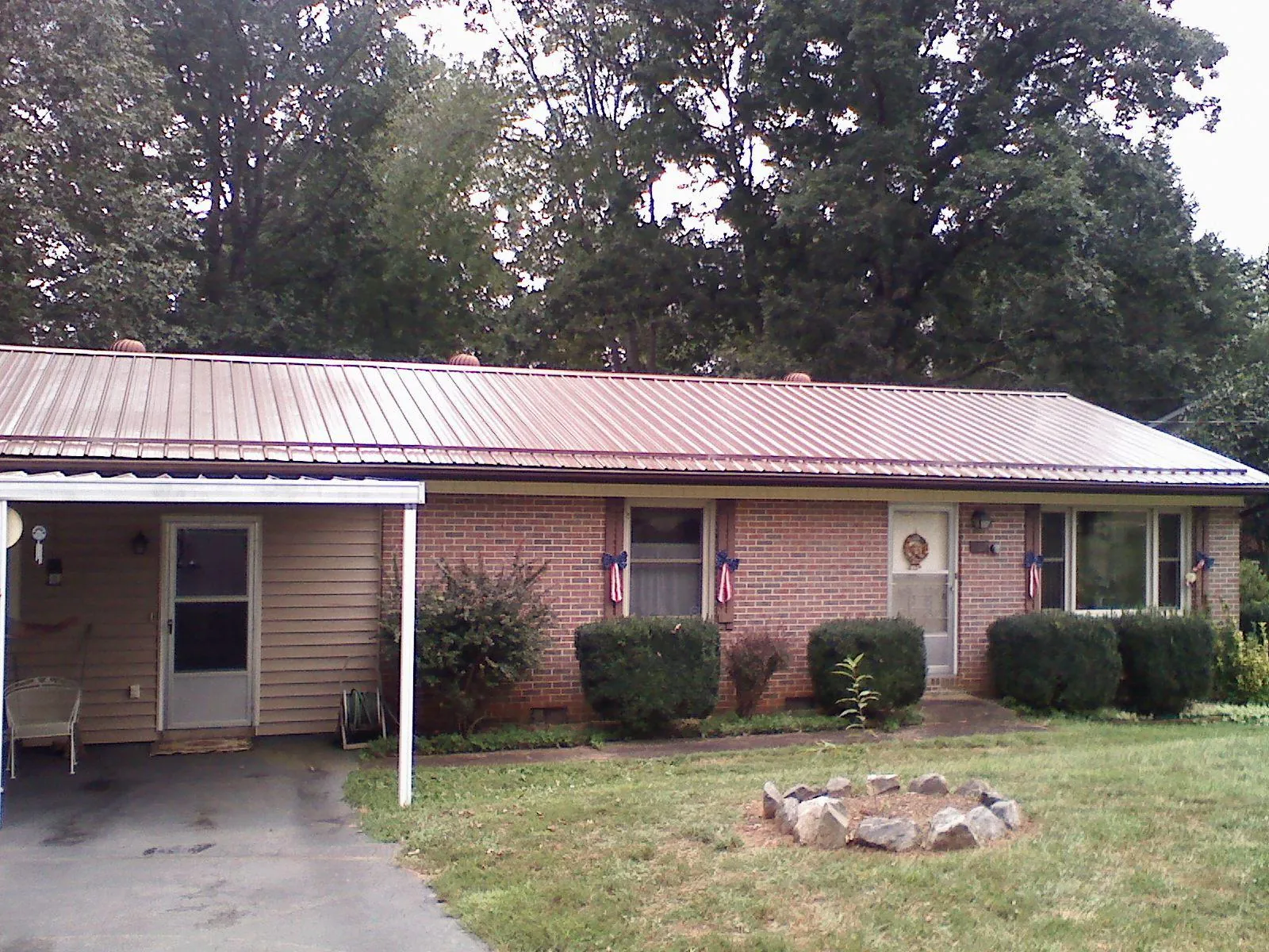 Bronze metal roof and carport on a brick ranch home — Roof Repair work by our crew in Boerne