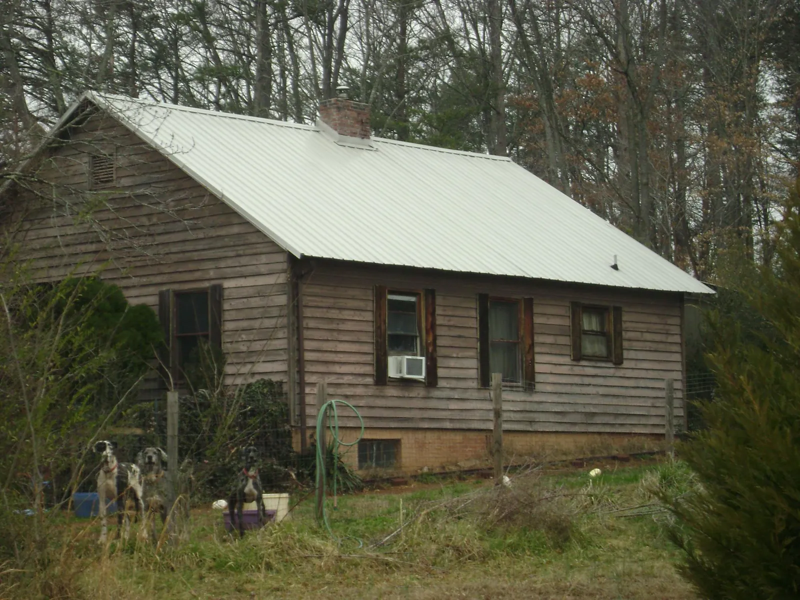 White metal roof on an old wood sided farmhouse, from a Asphalt Shingle Roof Repair job in Boerne